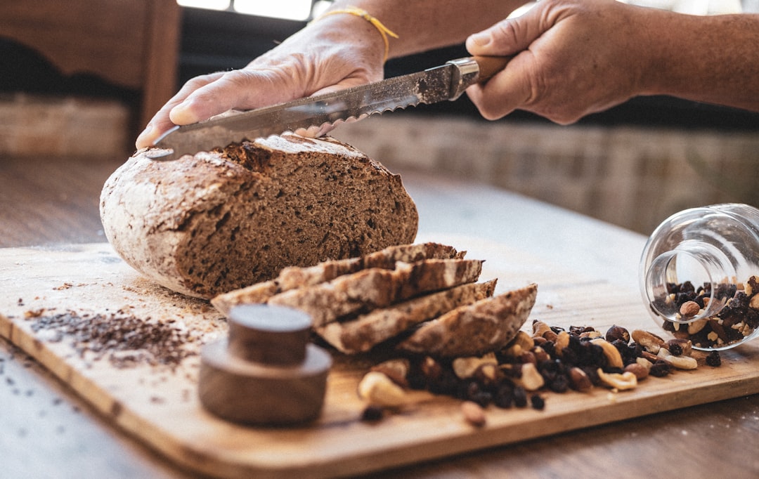 A chef slices a dense regional wheat-free bread at a European heritage food event