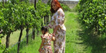 A mother and child share a harvest experience among vineyard rows during the EU grape harvest season