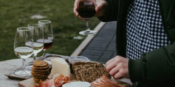 A sommelier carefully pours EU wines beside a regional cheese board at an elegant European table