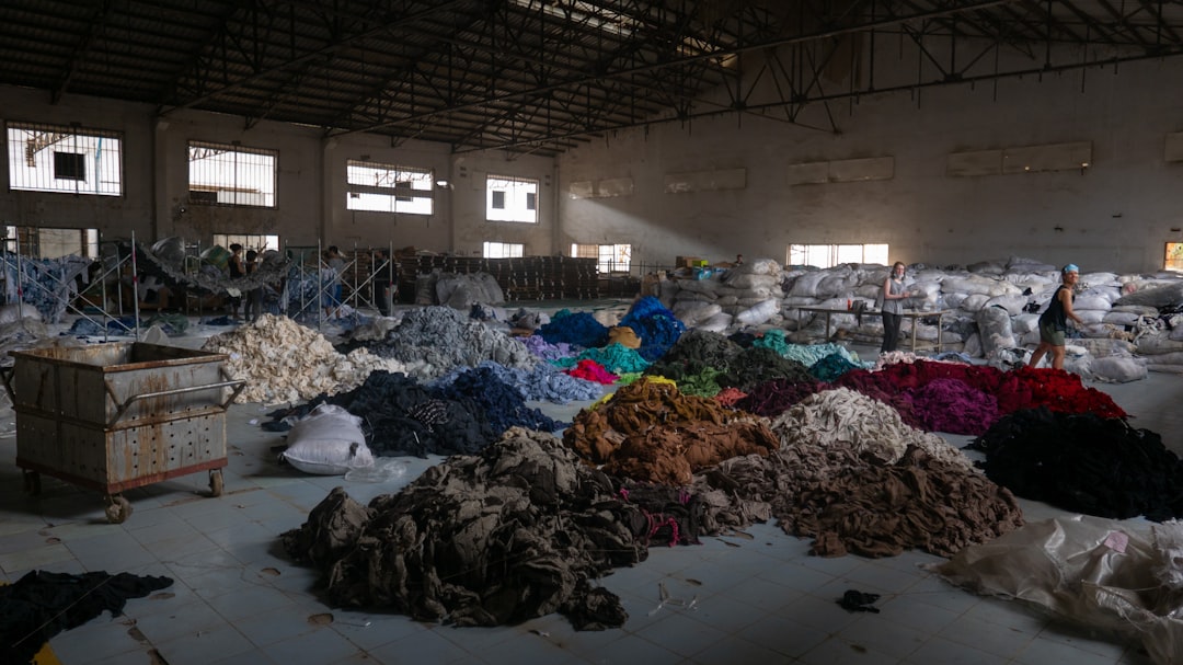 A textile worker sorting fabrics at a recycling facility that operates under certified textile recycling standards