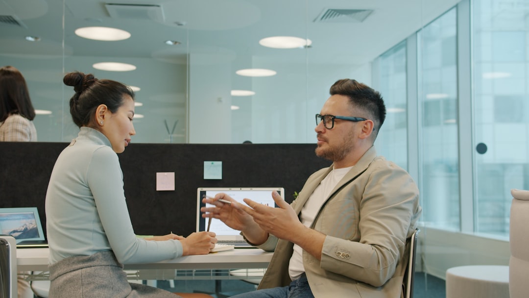 Two compliance professionals auditing supplier contracts together in a European company meeting room