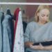 woman-reading-clothing-tag-unsplash - EUwebzine A woman examining a garment label in a clothing store to verify textile recycling certification marks