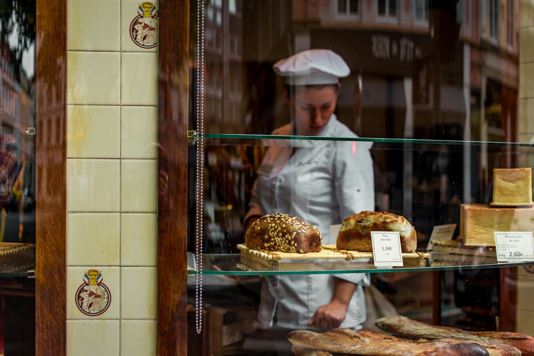 Eine Bäckerin misst für ihr herbstliches Backen glutenfreie Mehle wie Kastanie und Teff in eine Keramikschüssel