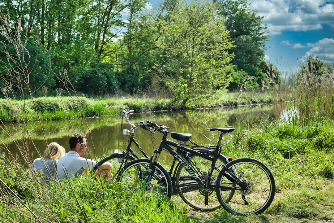 Un couple fait une pause le long des pistes cyclables du Danube dans la vallée de la Wachau, entouré de terrasses viticoles automnales pendant les vendanges.