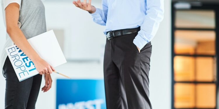 A startup founder reviews documents related to the EU competitiveness agenda at a modern office desk in Brussels.