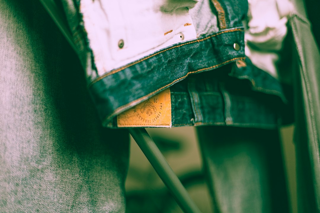 A shopper holding a garment with a visible green claims certification tag in a fashion boutique
