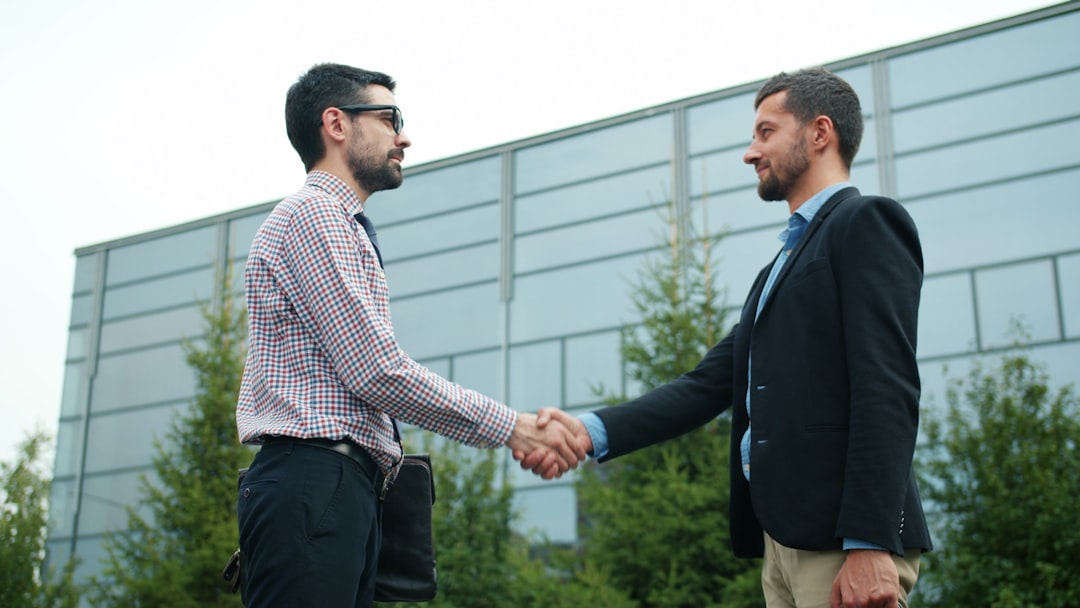 Two professionals shake hands after successfully renegotiating supplier contracts ahead of Q4 demand peaks