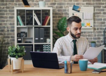 A growth-stage startup founder reviews EU state aid funding documents at her office desk