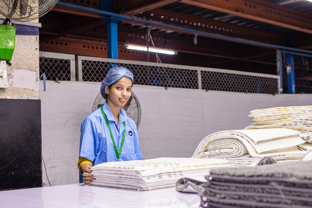 A factory worker inspecting certified organic textile fabric on a production floor