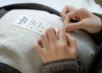 A woman examining a clothing label in a retail store to verify green claims before purchasing