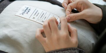 A woman examining a clothing label in a retail store to verify green claims before purchasing