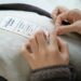 A woman examining a clothing label in a retail store to verify green claims before purchasing