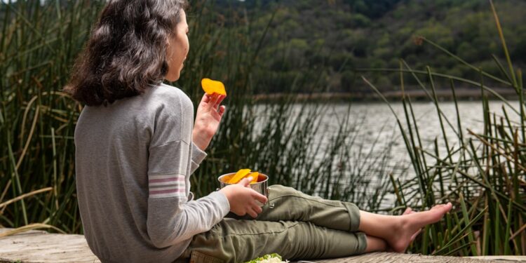 woman-eating-cheese-unsplash - EUwebzine A woman tasting EU regional cheeses in a stone cellar, surrounded by ageing wheels on wooden shelves
