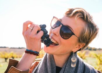 A woman sipping from a glass during a wine harvest visit at an EU-protected appellation vineyard in September