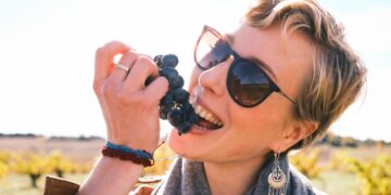 A woman sipping from a glass during a wine harvest visit at an EU-protected appellation vineyard in September