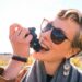A woman sipping from a glass during a wine harvest visit at an EU-protected appellation vineyard in September