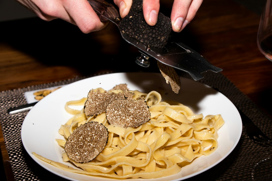 Chef shaving a white truffle onto a dish during Piedmont's truffle season