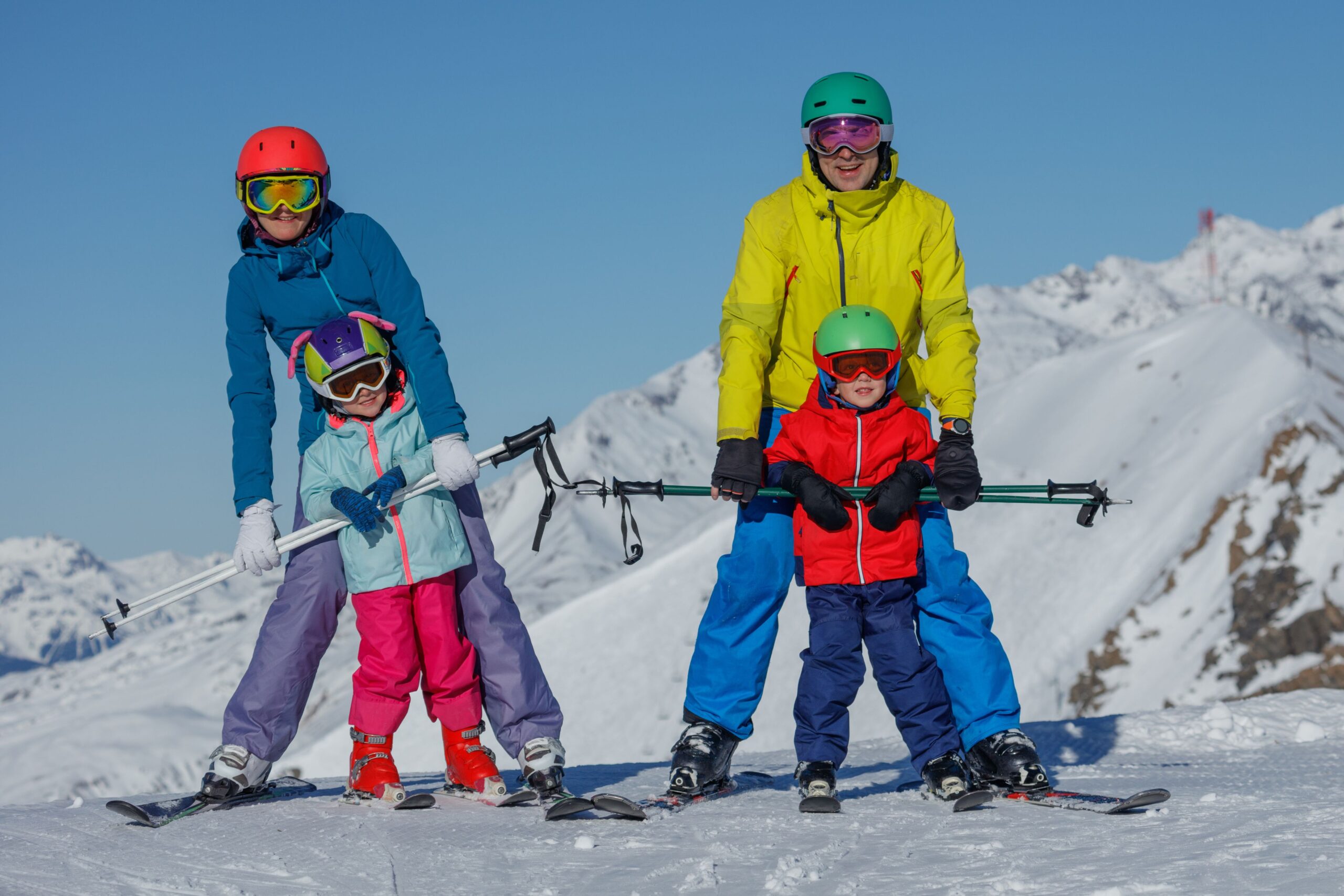 Família de esquiadores aproveitando as condições da temporada de neve precoce em destino de resort nos Alpes Europeus