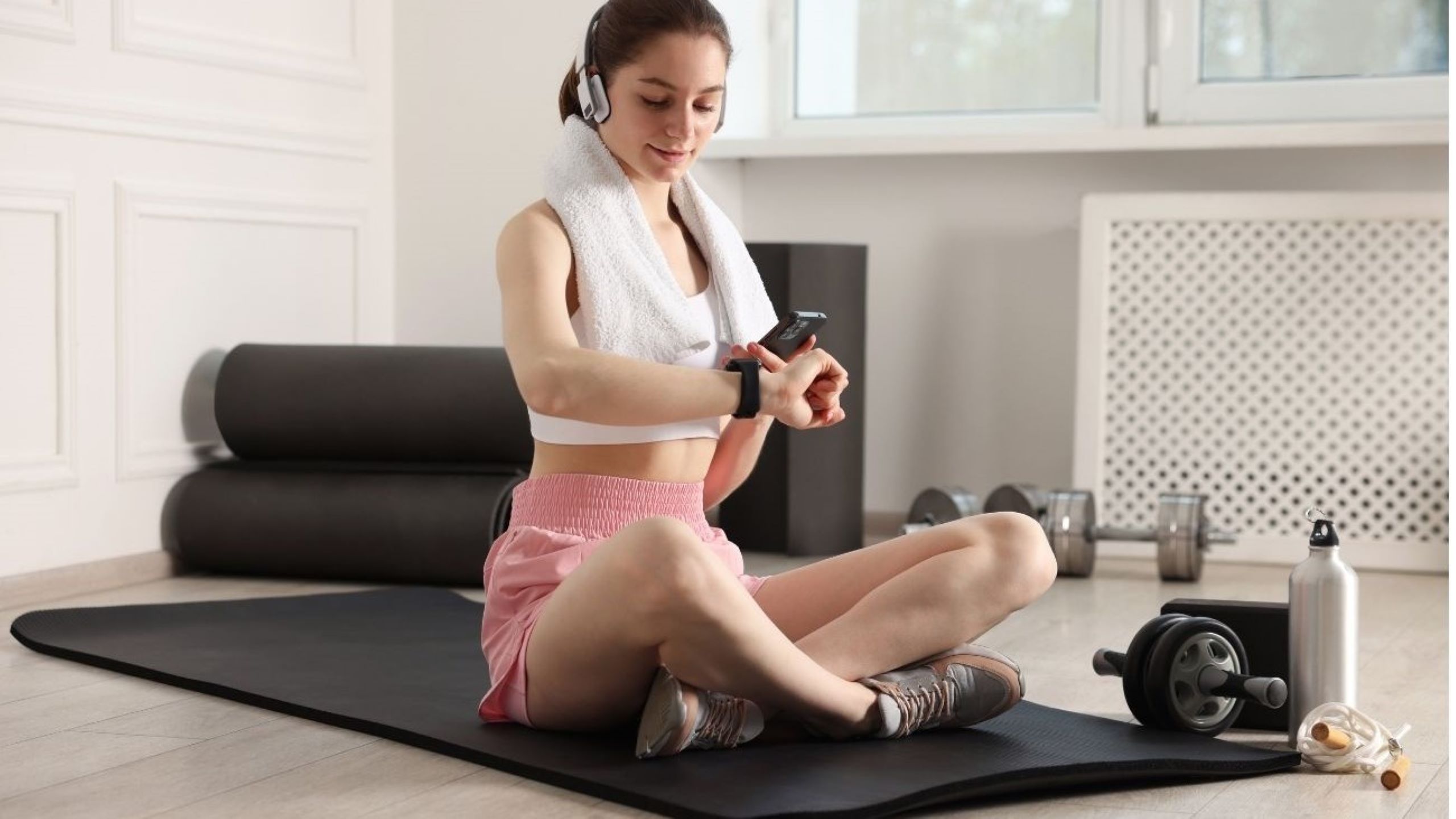 Donna europea che controlla un fitness tracker indossabile che mostra dati sulla salute che rappresentano le tendenze del benessere 2026 con tecnologia personalizzata basata sull'IA che monitora la frequenza cardiaca e le metriche di fitness mentale