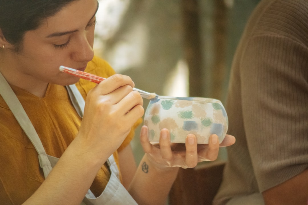 Uma mulher artesã a pintar à mão porcelana numa das regiões artesanais protegidas pela UE mais celebradas da Europa