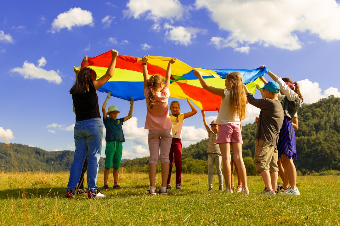 Un gruppo di bambini che frequentano campi estivi dell'UE, seduti all'aperto e che praticano attività linguistiche insieme