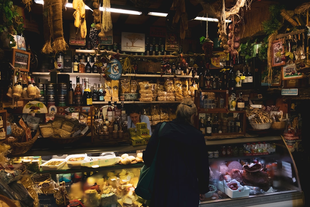 Uma mulher a provar Parmigiano Reggiano num caseificio italiano tradicional, um alimento de indicação geográfica da UE celebrado.