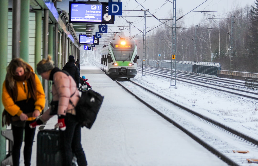 Uma mulher a embarcar num comboio europeu, a escolher a viagem ferroviária para reduzir a sua pegada de carbono nas férias de verão