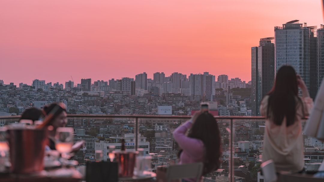 Una donna che gode della cena in uno dei ristoranti in terrazza più eleganti di Parigi, con lo skyline della città che brilla al tramonto