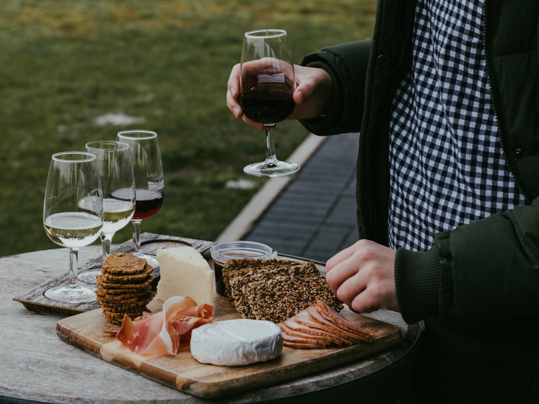 Un sommelier versa con cura vini dell'UE accanto a un tagliere di formaggi regionali a una tavola europea elegante