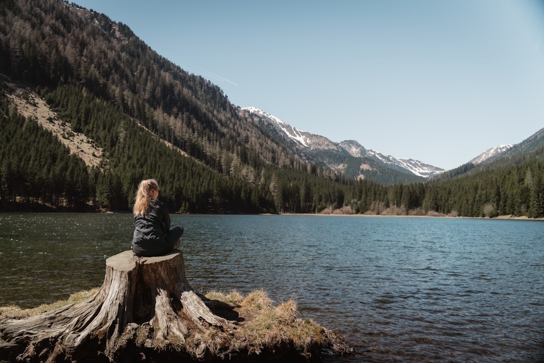 Uma mulher a deslizar pelas águas claras de um destino de lago da UE rodeado por paisagens montanhosas