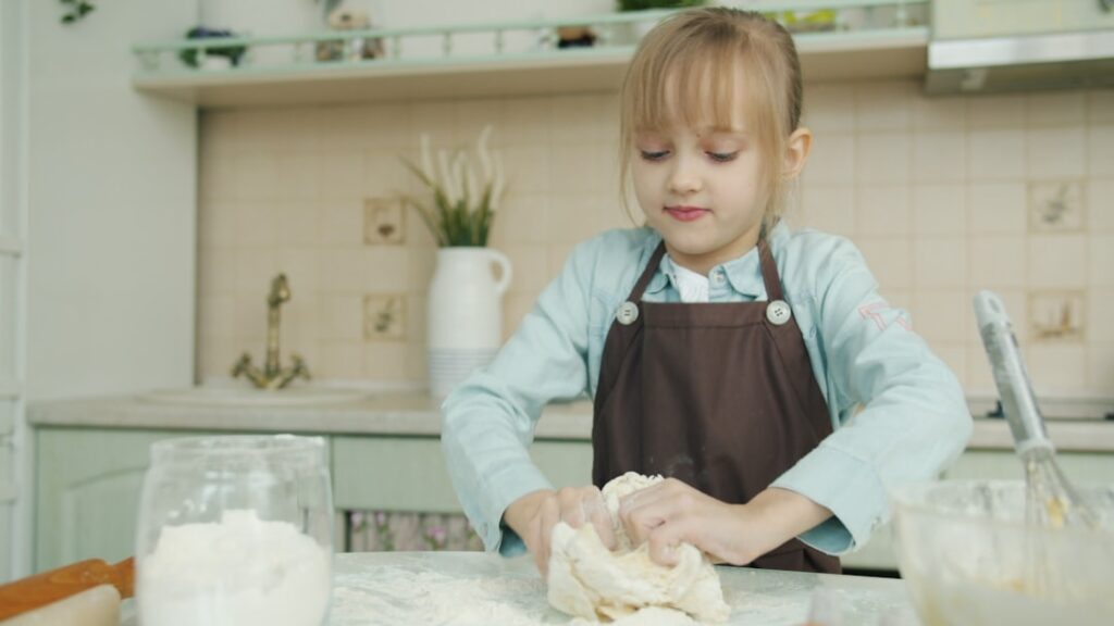 A young child learning bread-making techniques during harvest workshops at a traditional European rural farm