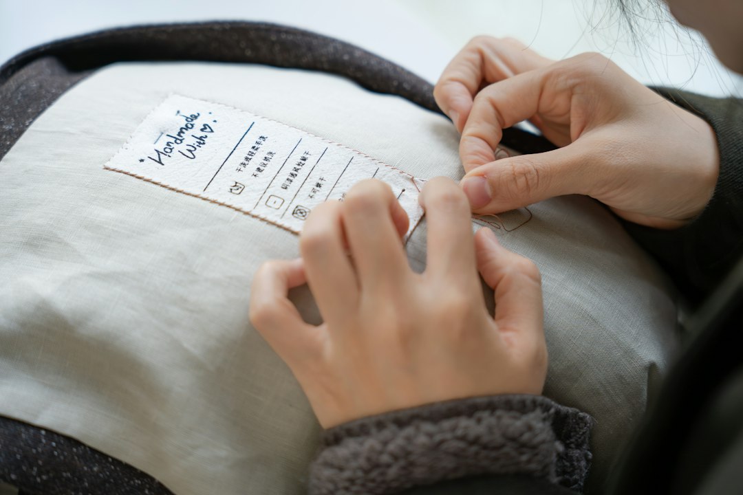 Uma mulher a examinar uma etiqueta de roupa numa loja de retalho para verificar alegações ecológicas antes de comprar