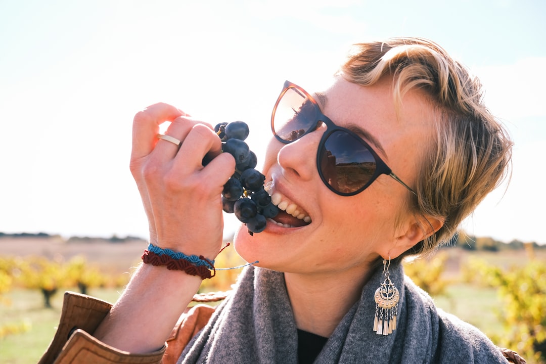 A woman sipping from a glass during a wine harvest visit at an EU-protected appellation vineyard in September