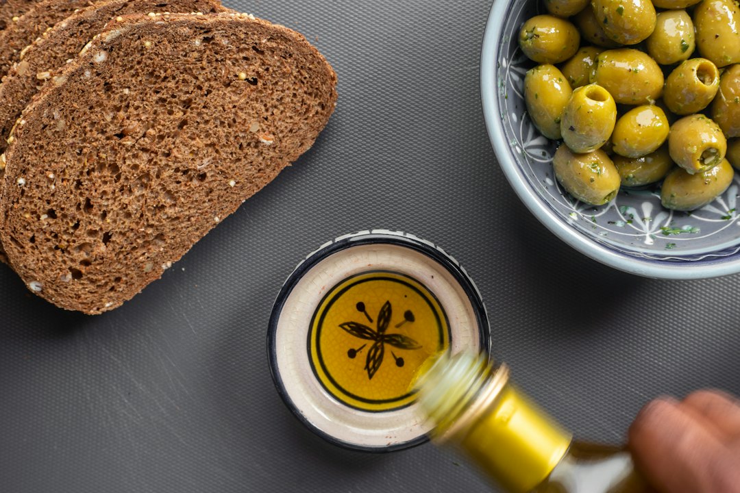 Chef pouring extra virgin olive oil into a pan in a Mediterranean kitchen
